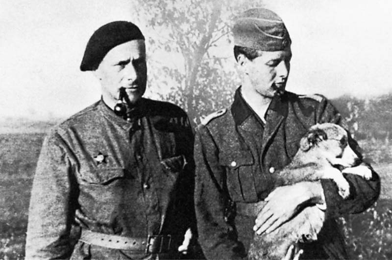 Friedrich&nbsp;Wolf steht neben Graf von Einsiedel, der einen Hund auf dem Arm tr&auml;gt.