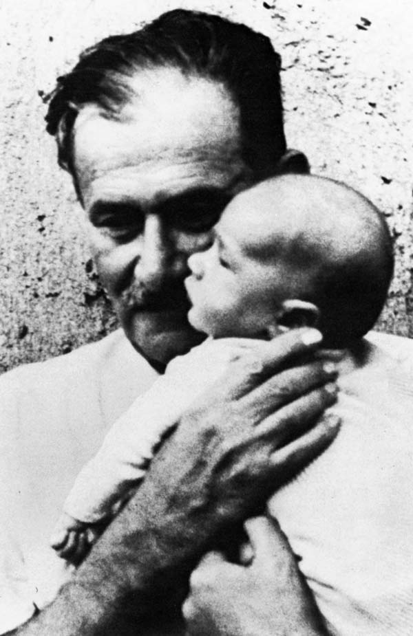 Friedrich&nbsp;Wolf h&auml;lt ein Baby auf dem Arm.
