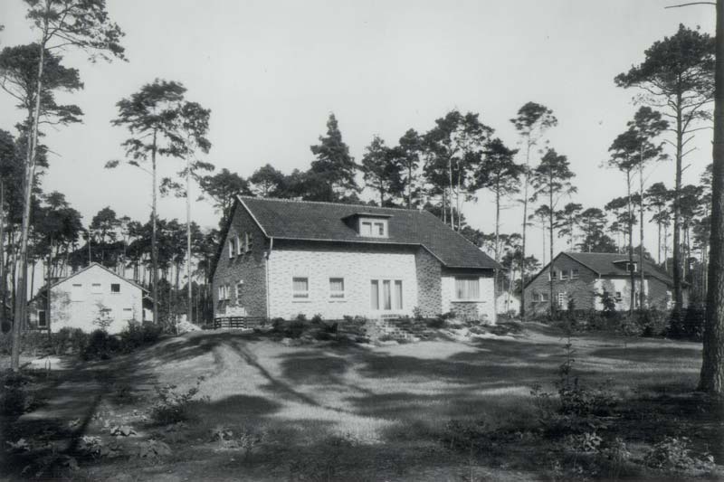 Schwarz-Weiß-Foto eines Klinkerhauses mit Garten.