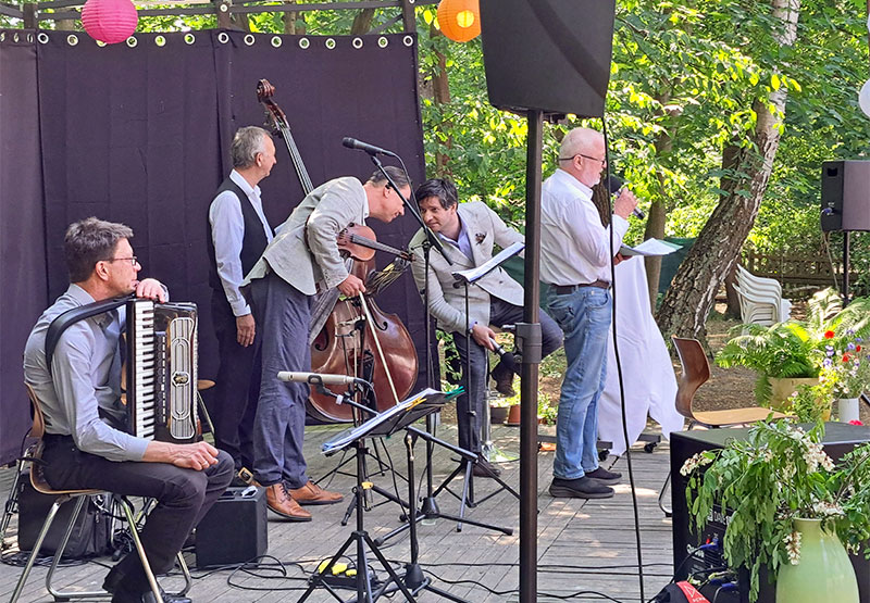 Männer musizieren auf einer Bühne und interagieren