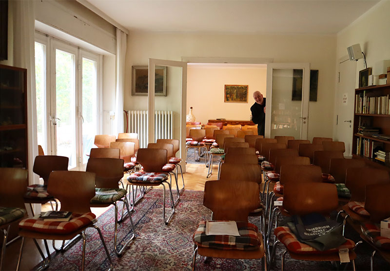 Frank Jahnel schaut in das bestuhlte Wohnzimmer vor einer Veranstaltung