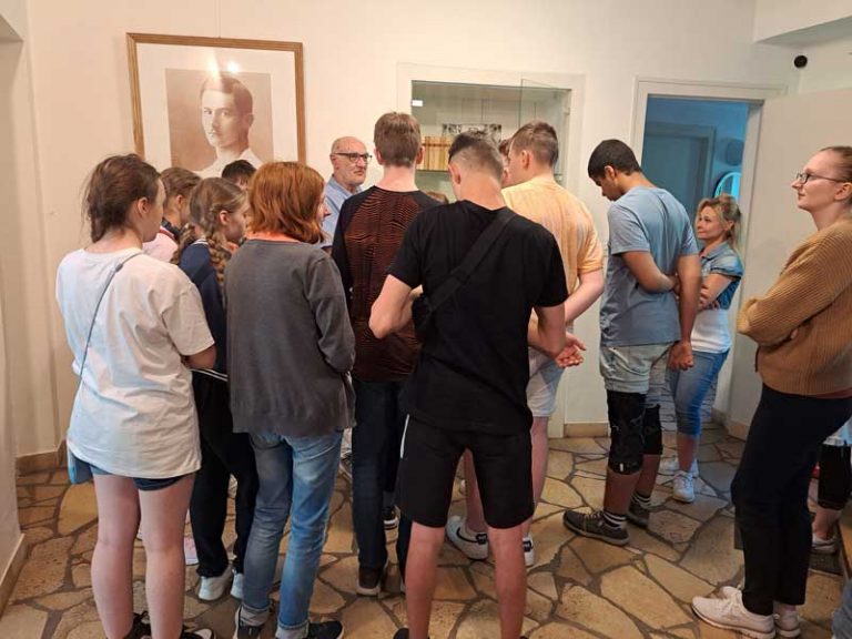 Menschen hören bei einer Führung dem Erzähler zu.