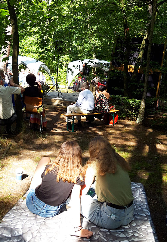 Menschen sitzen im Sonnenschein im Garten