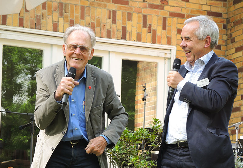 zwei Männer mit Mikrofon unterhalten sich und lachen