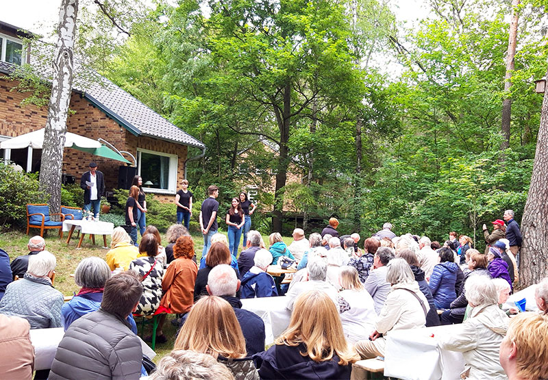 Schülerinnen und Schüler führen ein Theaterstück im Garen auf