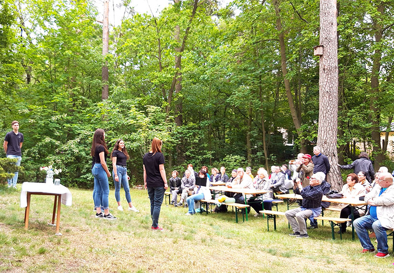 Schüler führen im Garten ein Theaterstück auf