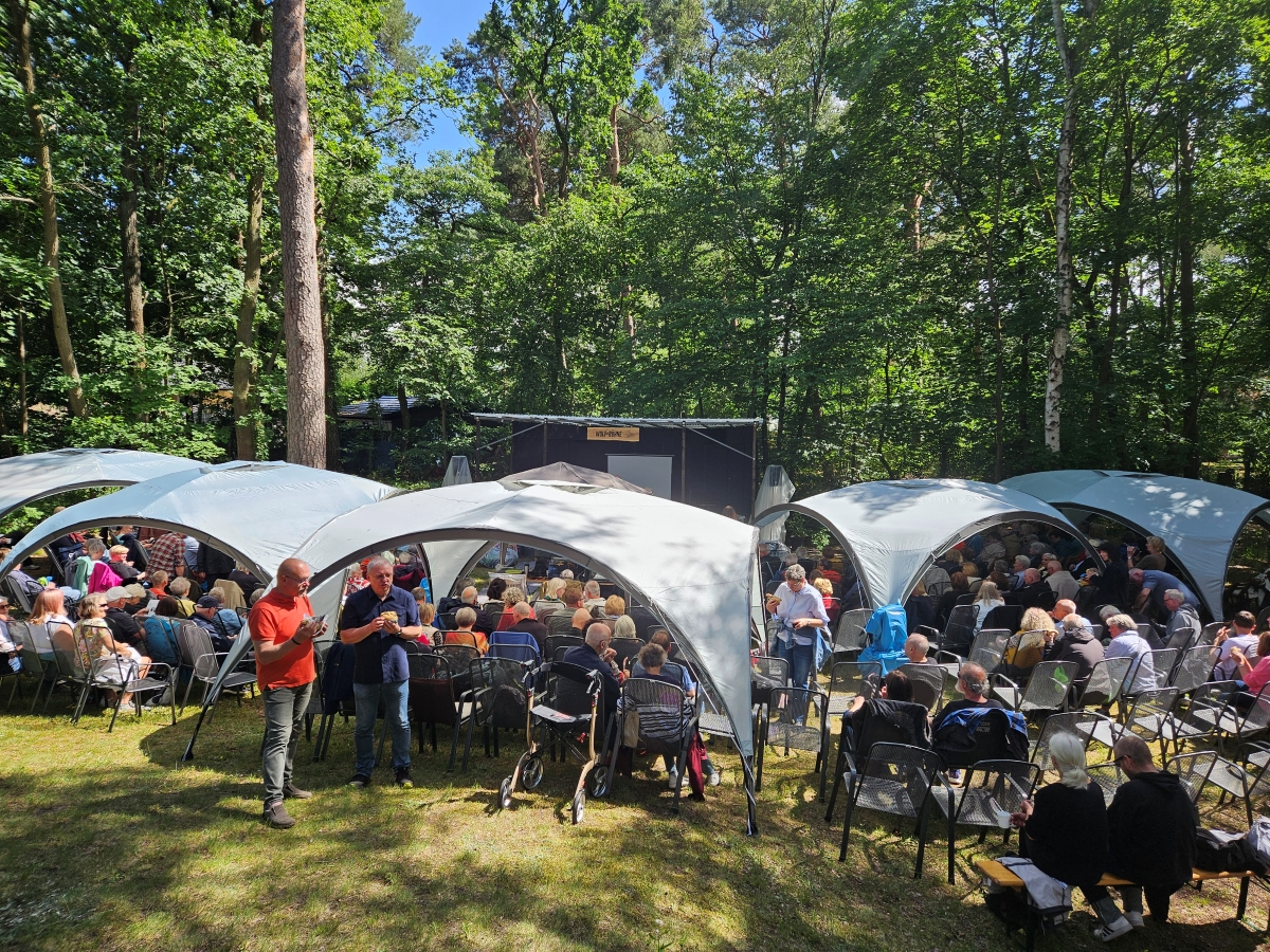 Überblick über den Kultur-Garten mit Zelten, Publikum und Wolf-Bühne im Hintergrund.