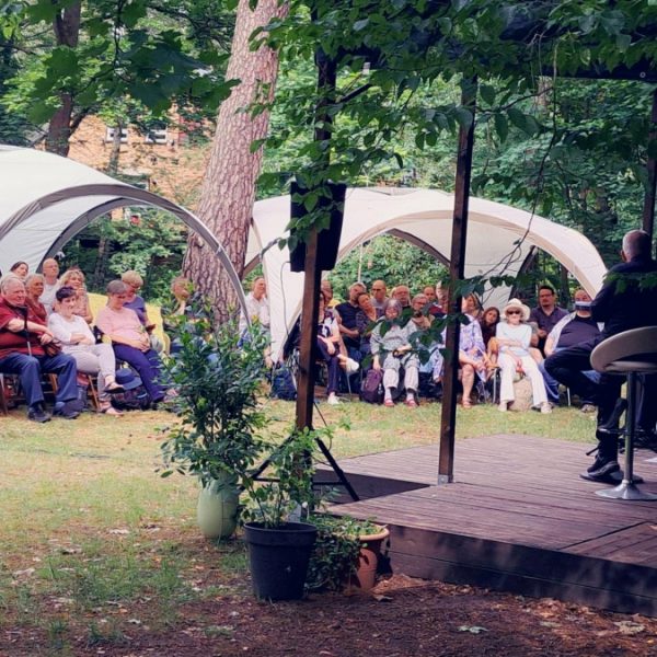 Das Foto zeigt eine Verantaltung im Garten des Friedrich-Wolf-Literaturhauses mit Publikum und Zelten.