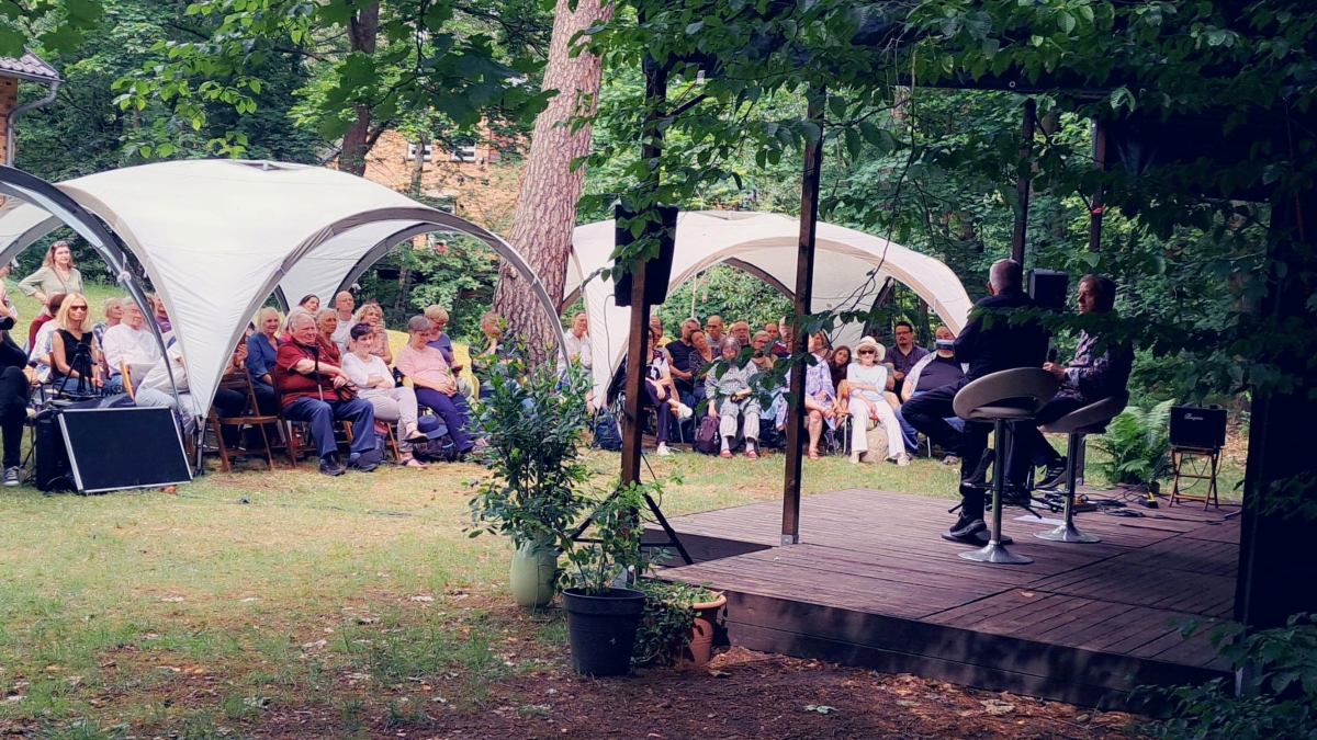 Das Foto zeigt eine Verantaltung im Garten des Friedrich-Wolf-Literaturhauses mit Publikum und Zelten.